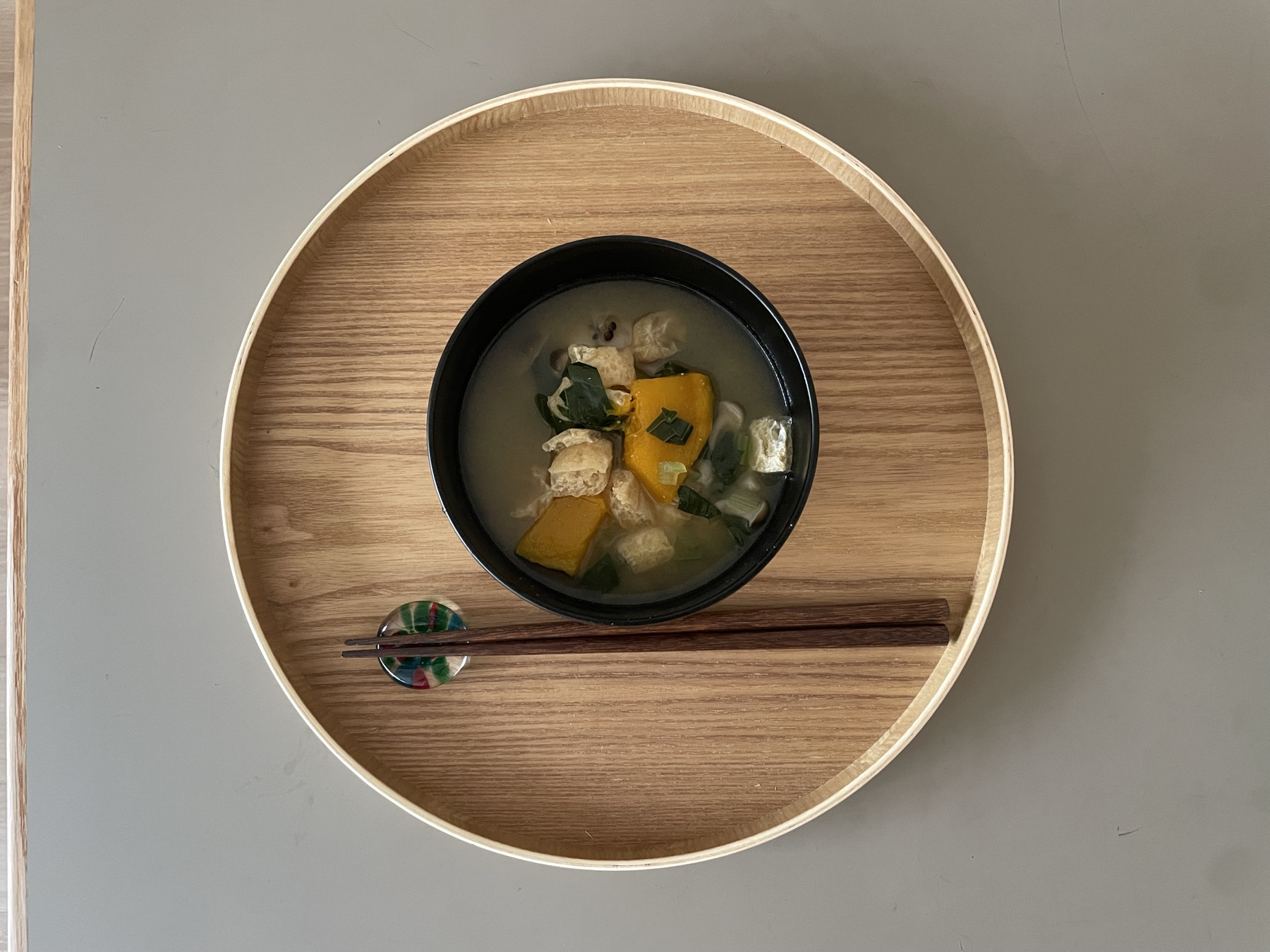 黒の大のお椀に味噌汁を入れてお盆に載せた写真