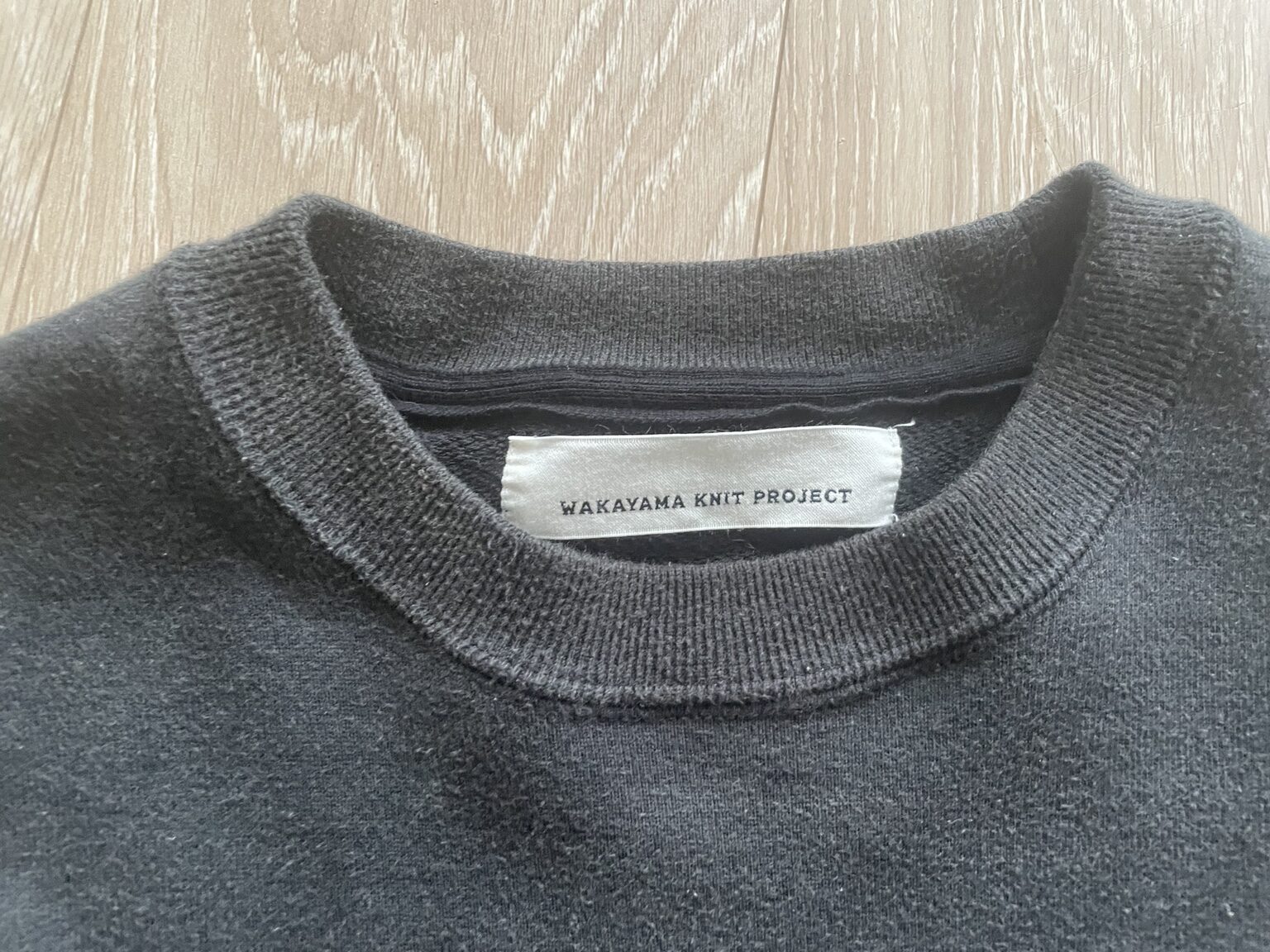 WAKAYAMA KNIT PROJECTのタグと襟元のリブ、生地の表情